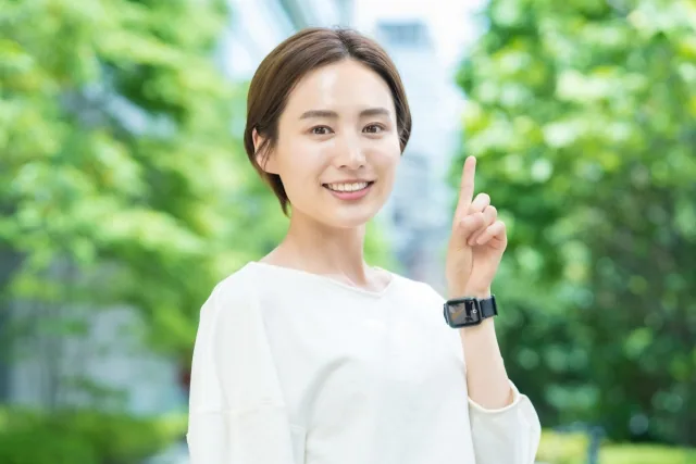 人差し指を挙げている４０代の女性