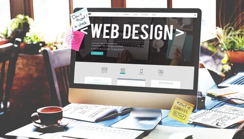 WEBデザイナーと記載されたパソコンとその仕事に必要な資料