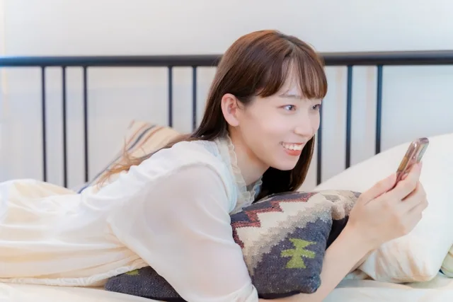 携帯を嬉しそうに触っている女性