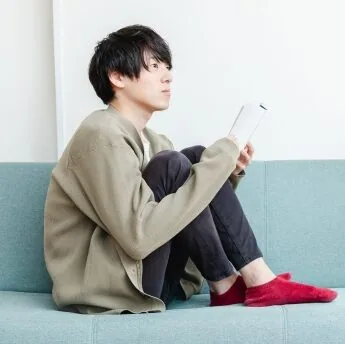 ソファーに座って寂しそうな男性