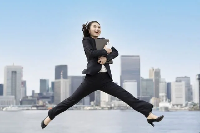 柔軟に働いている楽しそうなジャンプしている女性の様子