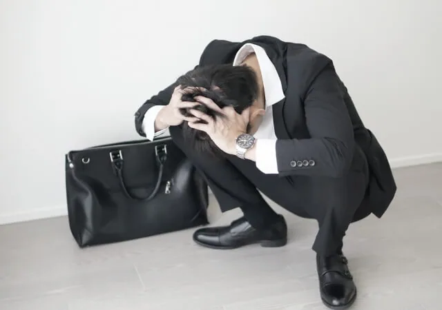 精神的に限界にきてうずくまっている男性