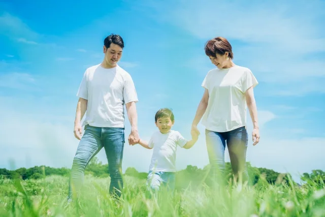 夫婦と手を真ん中でつないでいる子供