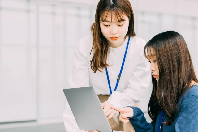 画面を指差す二人の女性