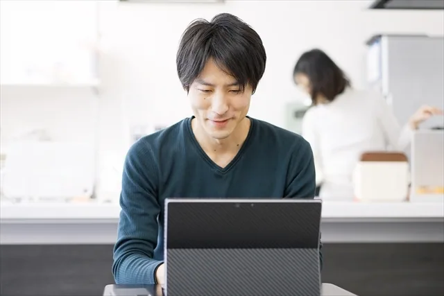 パソコンで学んでいる嬉しそうな男性