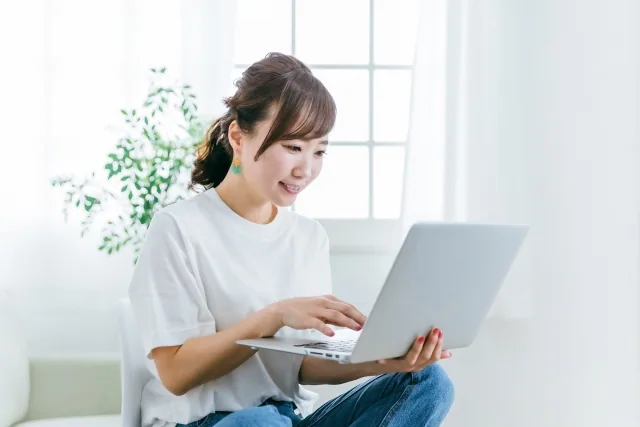 パソコンに向かって笑顔の女性