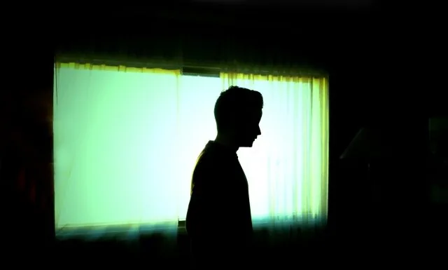 暗い中で立っている男性の影