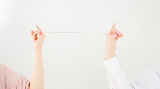 毛糸で運命のつながりがある男女の指