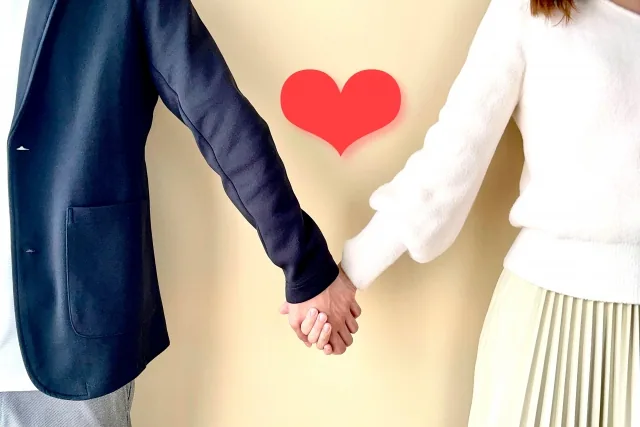 ハートマークと手をつないでいる男女