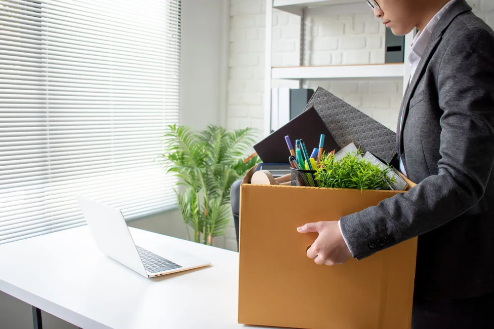 新しい職場の机に自分の荷物を置く男性