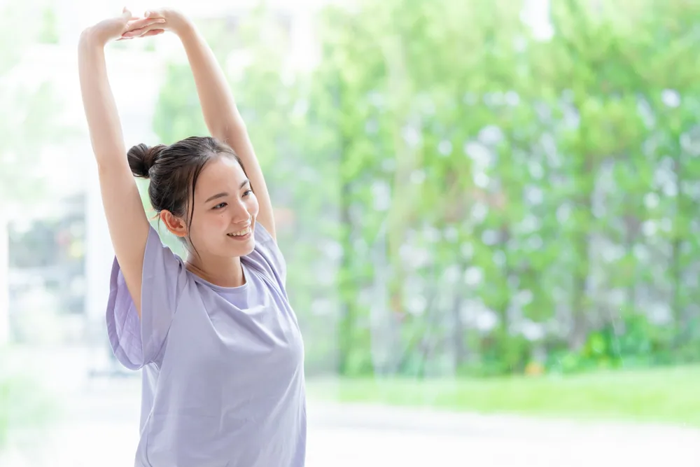 野外で運動をしてのびのびしている女性