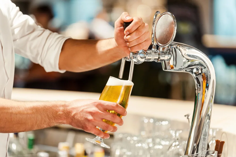 バーテンダーがビールをついでいる手