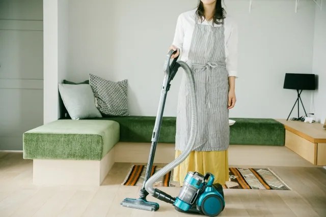 掃除機を持っている専業主婦の女性
