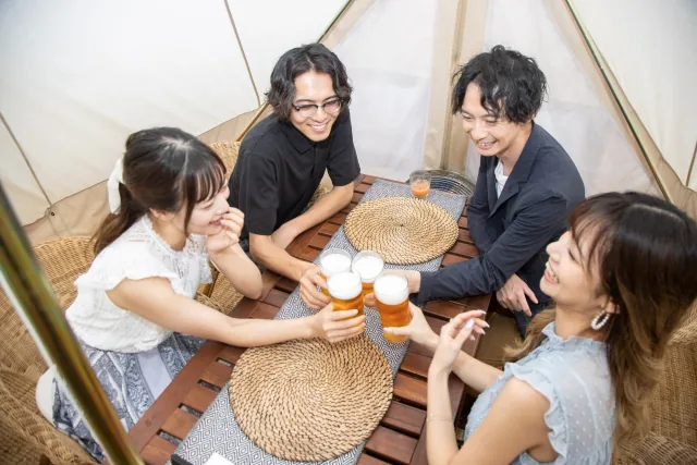 ２人の男性と女性が乾杯している様子
