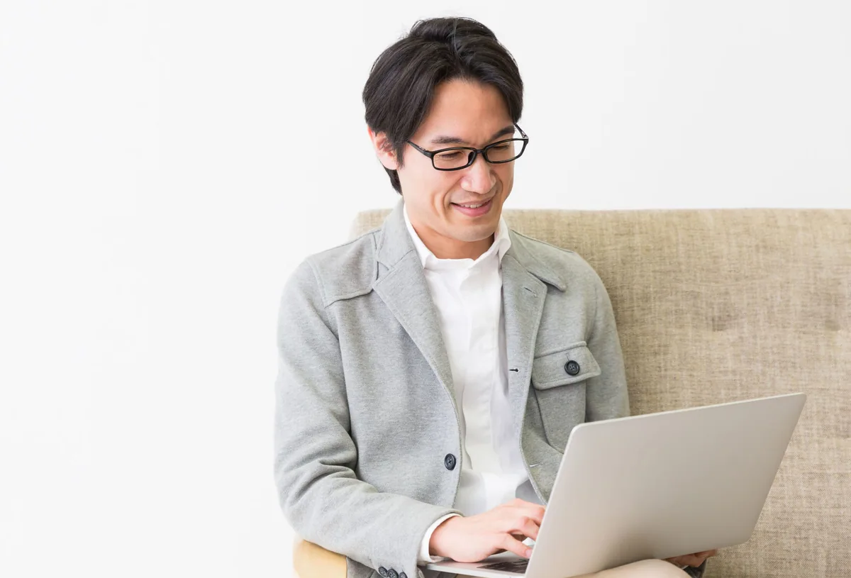 笑顔で嬉しそうなパソコンの前にいるフリーランスの男性