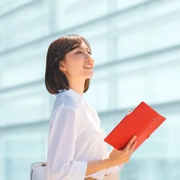 笑顔で上を見て前向きに考えている女性