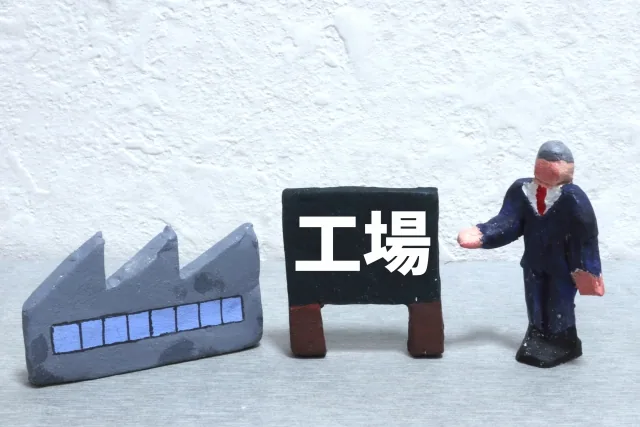 工場と書かれた文字と粘土の男性