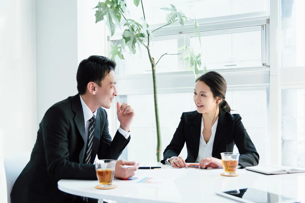 話をしているビジネス姿の男女