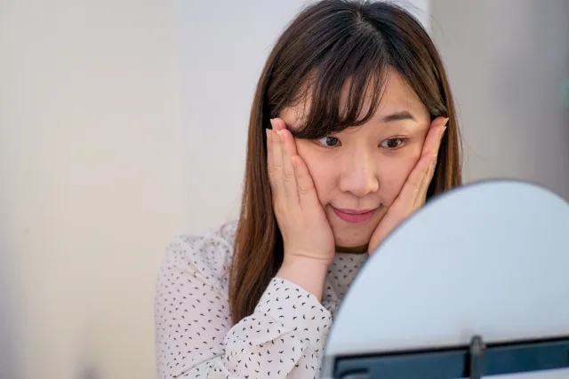 鏡で自分を見ている女性