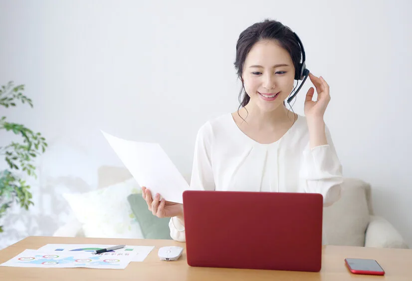 自宅でパソコンで話しながら仕事をしている女性