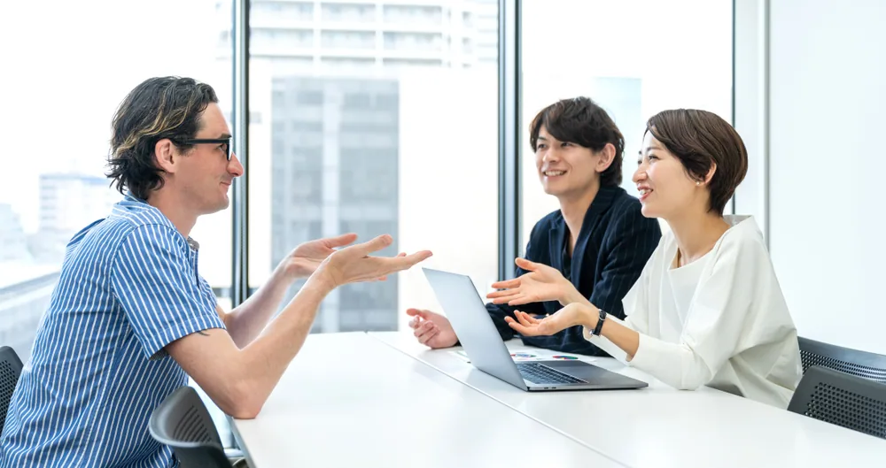 外国人とオフィスで商談している日本人の男女