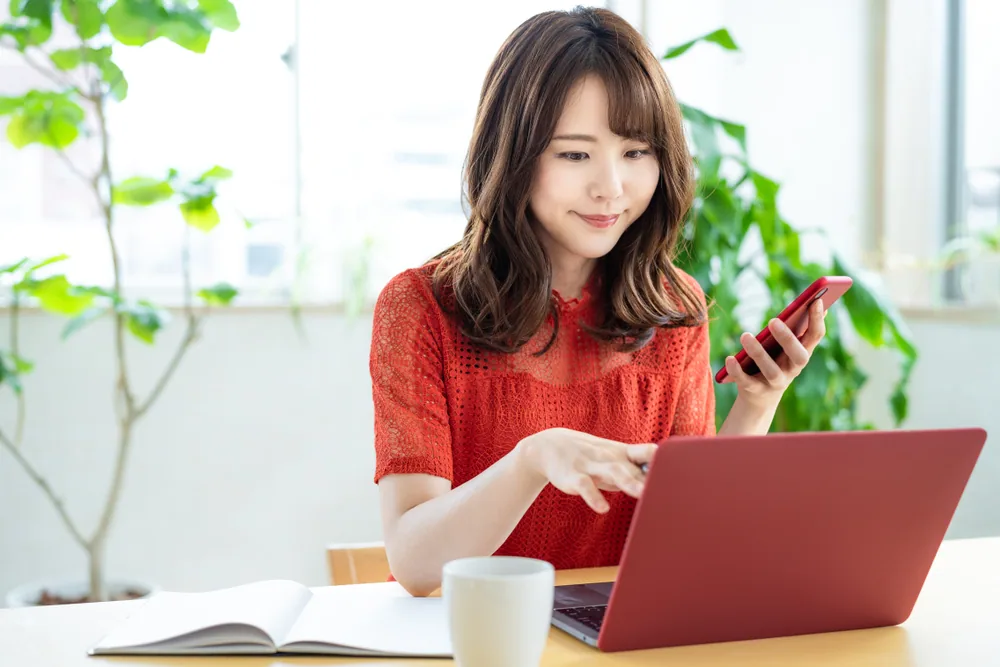 事務所でパソコンに向かって仕事をしている女性