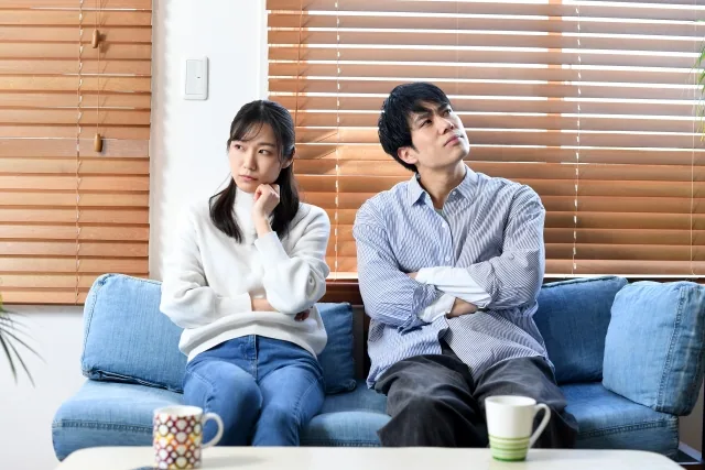 ソファーで不幸せな顔をして座っている男女