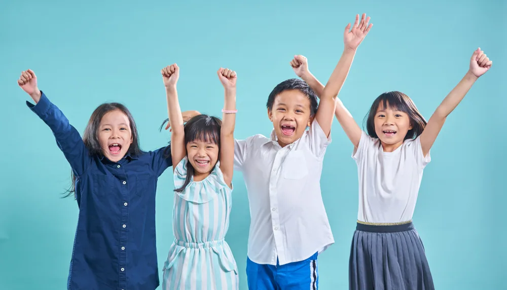 複数の子供が手をあげて喜んでいる様子