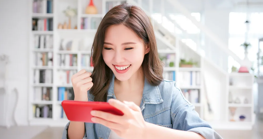 携帯を見て笑顔の女性