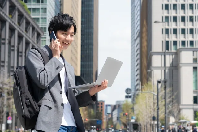 男性がPCを持っている