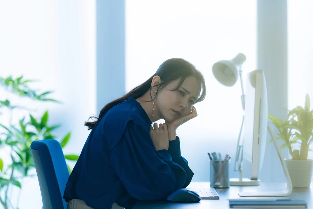 パソコンの前で考えている女性