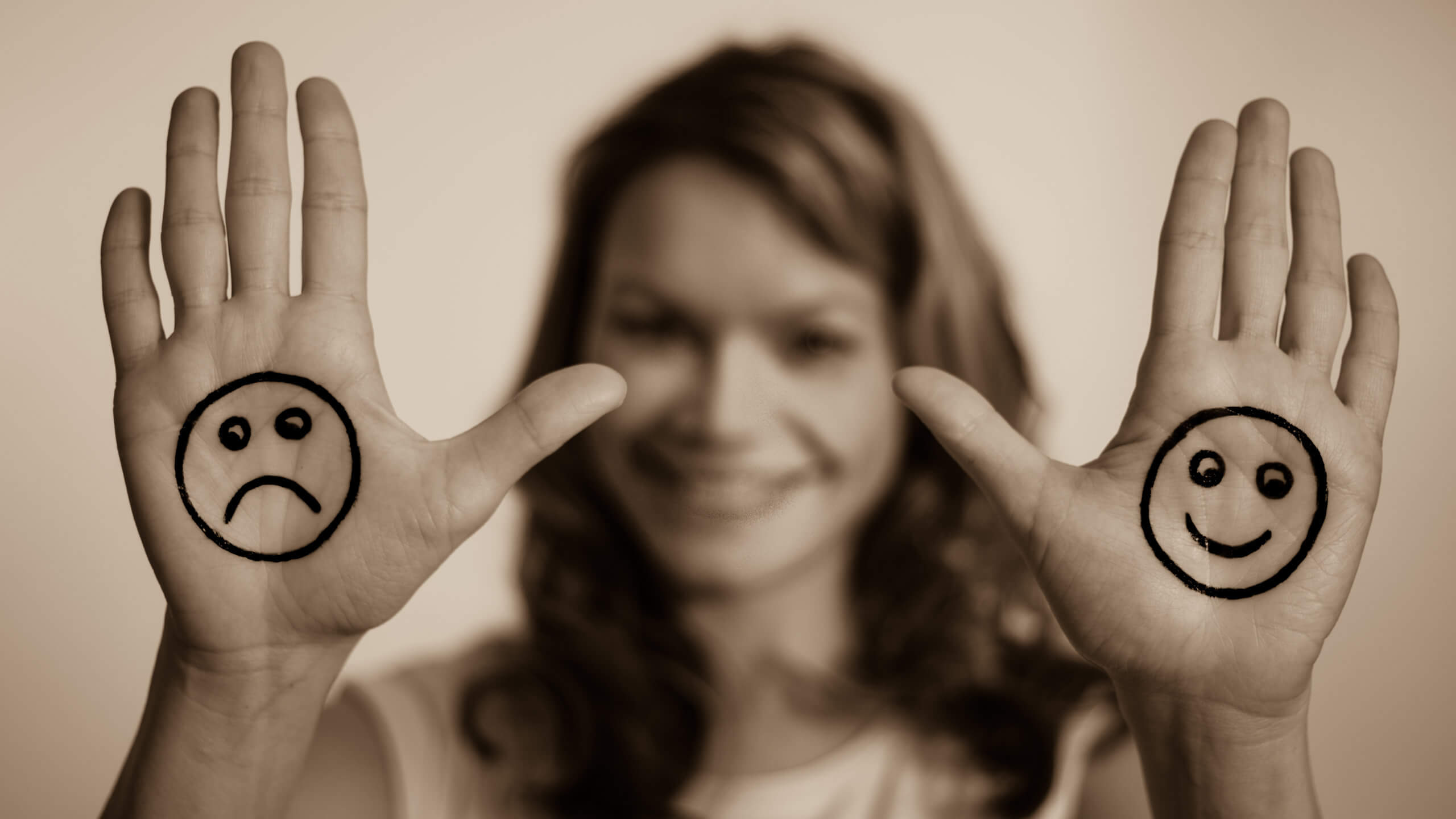 両手に書かれた笑った顔と困った顔