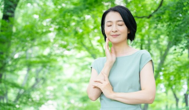 緑の中でリラックスしている様子の女性