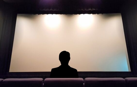 ブランクのスクリーンを映画館で観ているビジネスマン