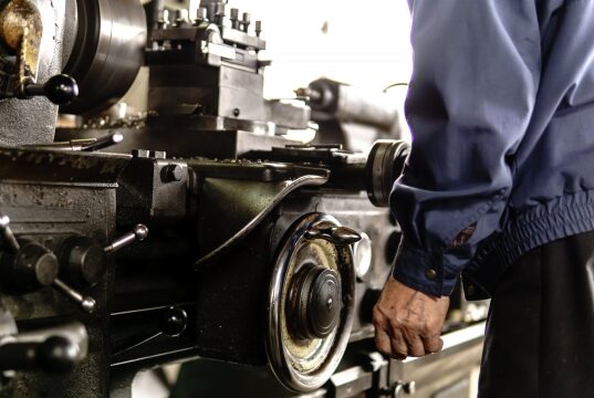 工場作業をしている男性の手と機械