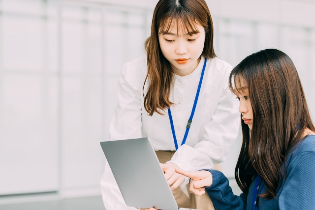画面を指差す二人の女性
