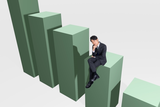 棒グラフの上に座っているスーツ姿の男性