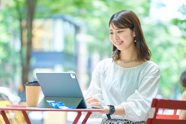 女性が外でパソコンで仕事をしている様子