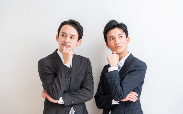 考えているスーツ姿の2人の男性