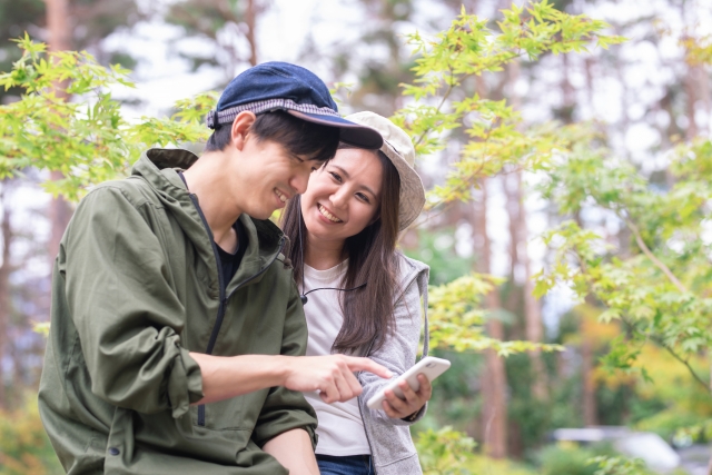 男性と女性が携帯を見て笑っている様子