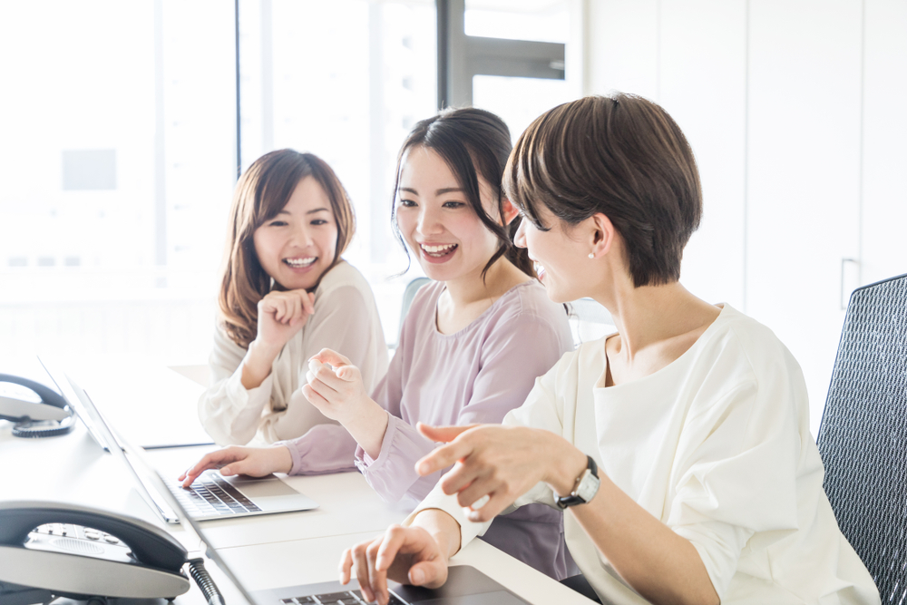 オフィスで仲良い笑顔の３人の女性