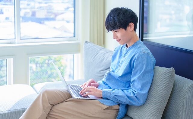 リラックスして在宅ワークをしている男性
