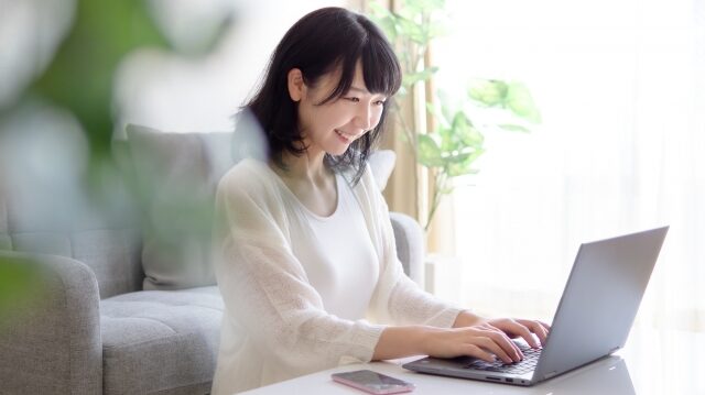幸せそうにパソコンを向かっている女性