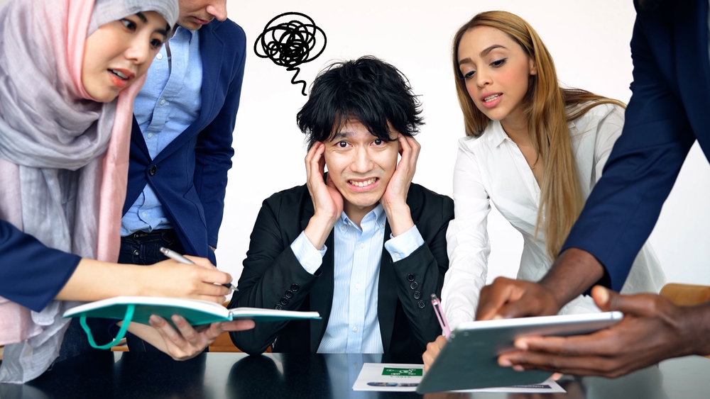外国人に囲まれて困っている男性